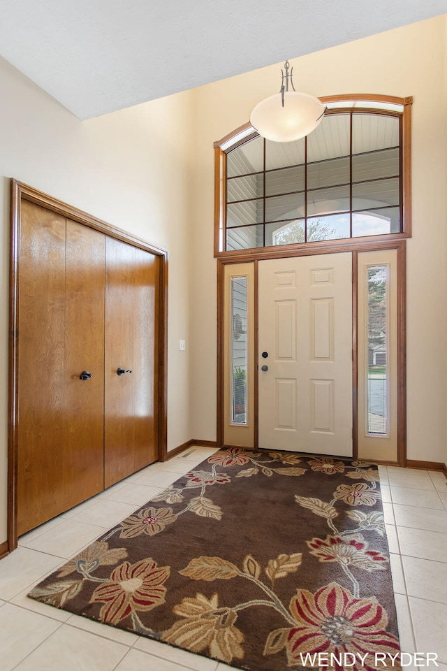 foyer entrance with baseboards and light tile patterned floors