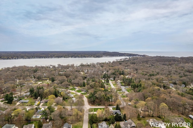 drone / aerial view featuring a water view and a wooded view