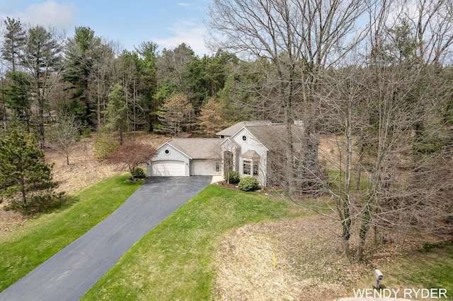 view of front of home featuring an attached garage, a front lawn, and aphalt driveway