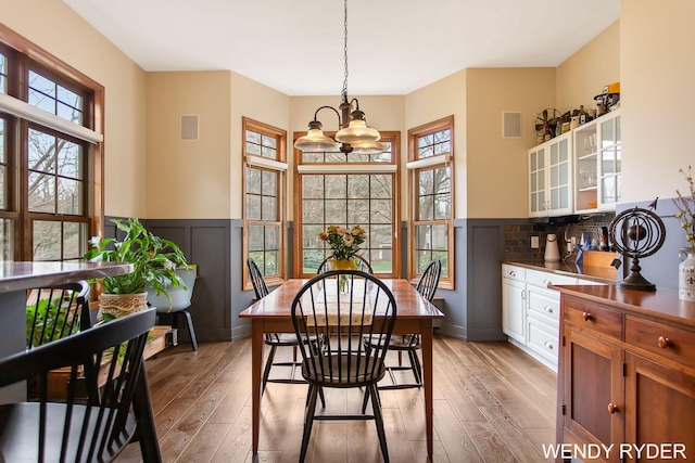 dining space with visible vents, light wood-style flooring, and a chandelier