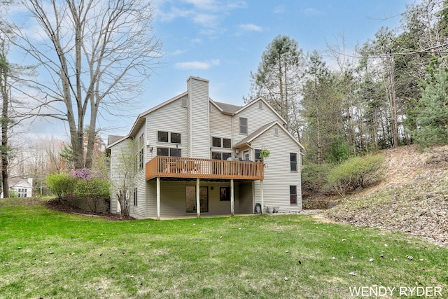 back of property with a lawn, a deck, and a chimney