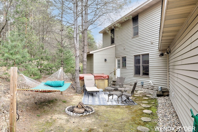 view of yard with a hot tub, a patio area, and an outdoor fire pit