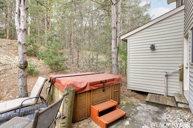 exterior space featuring a hot tub and a forest view