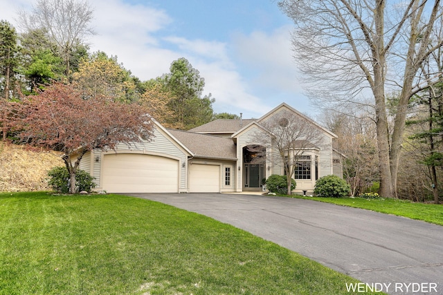 view of front of house featuring a garage, aphalt driveway, roof with shingles, and a front yard