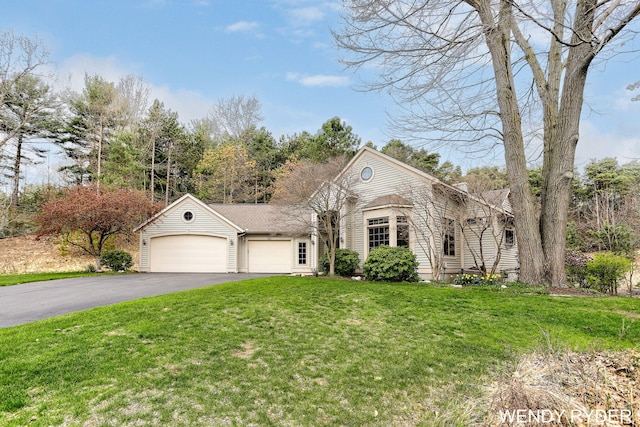 view of front of home with driveway, a front yard, and a garage