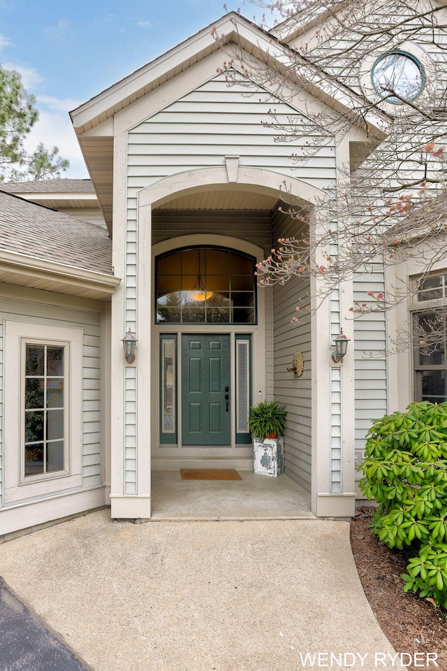 property entrance featuring roof with shingles