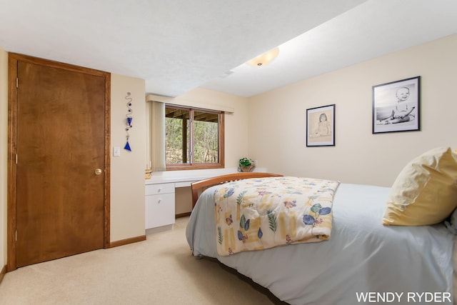 bedroom with baseboards and light carpet