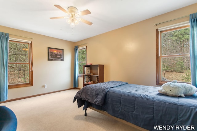 carpeted bedroom with a ceiling fan and baseboards