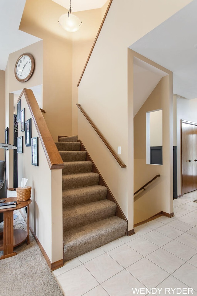 stairs with baseboards and tile patterned floors