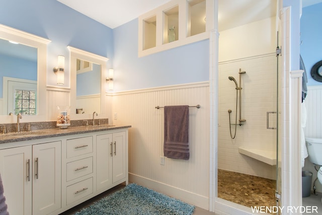full bath with a wainscoted wall, a sink, and a stall shower