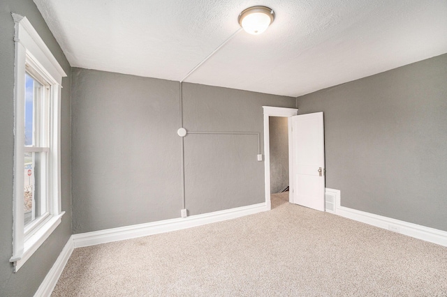 carpeted empty room with baseboards