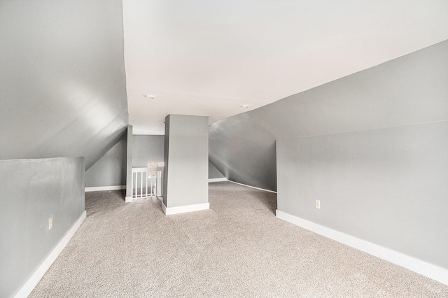 bonus room with carpet floors, baseboards, and lofted ceiling