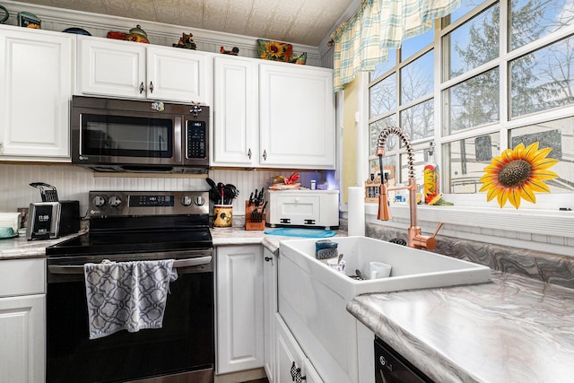 kitchen with a sink, white cabinetry, an ornate ceiling, and stainless steel appliances
