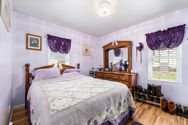 bedroom with baseboards and light wood finished floors