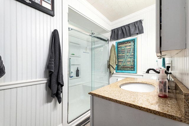 bathroom with vanity, crown molding, and a stall shower