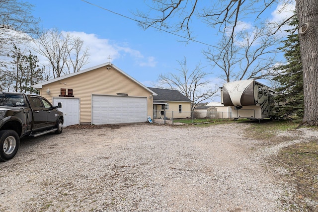 view of home's exterior with fence and a detached garage