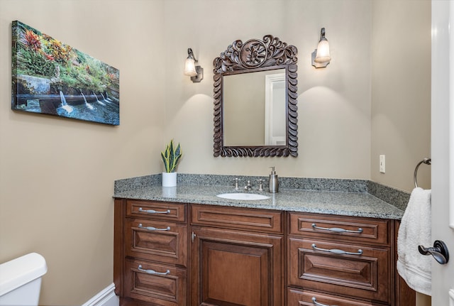 half bathroom with vanity and toilet