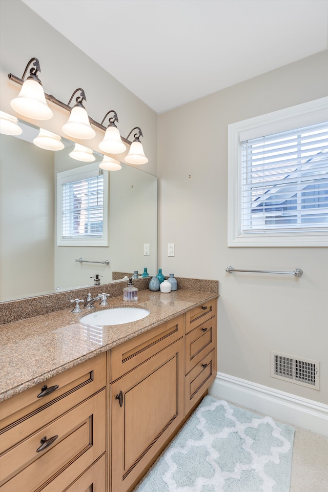 bathroom with visible vents, a healthy amount of sunlight, and vanity