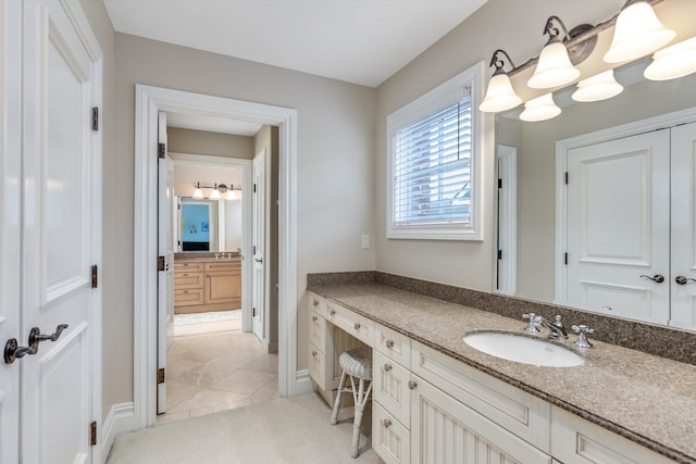 bathroom with vanity, baseboards, and tile patterned flooring