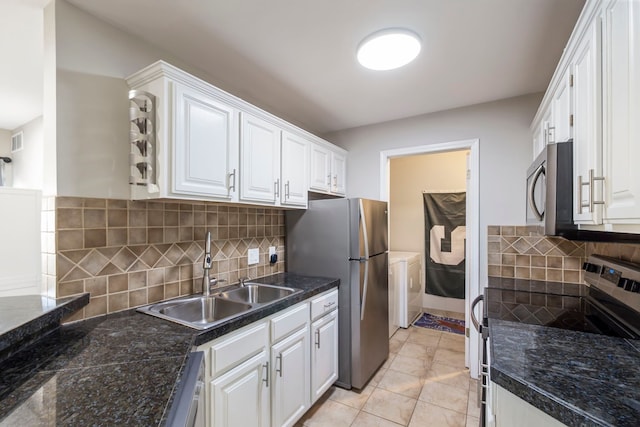 kitchen with white cabinets, backsplash, stainless steel appliances, and a sink