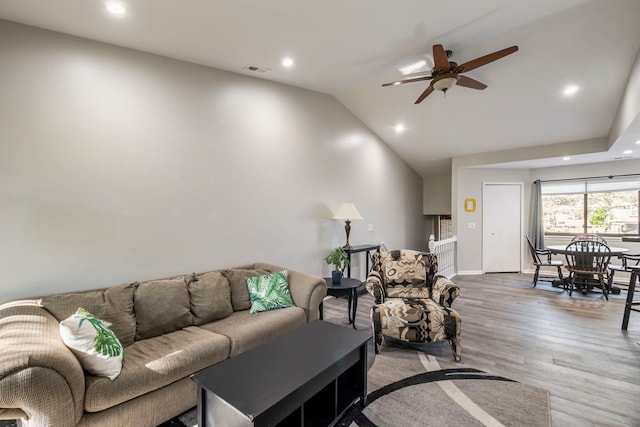 living room featuring light wood-type flooring, visible vents, recessed lighting, vaulted ceiling, and ceiling fan