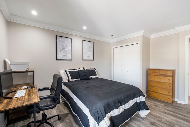 bedroom with baseboards, crown molding, and wood finished floors