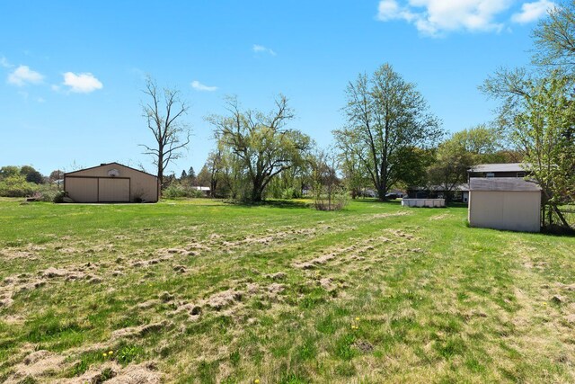 view of yard with a detached garage and an outbuilding