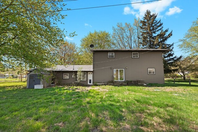 back of house with a storage shed, a yard, fence, and an outdoor structure
