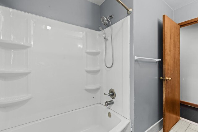 bathroom featuring baseboards, tile patterned flooring, and bathtub / shower combination