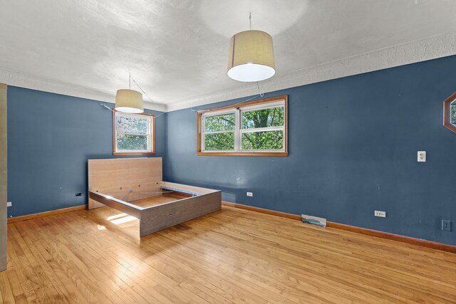 unfurnished bedroom featuring baseboards and hardwood / wood-style flooring