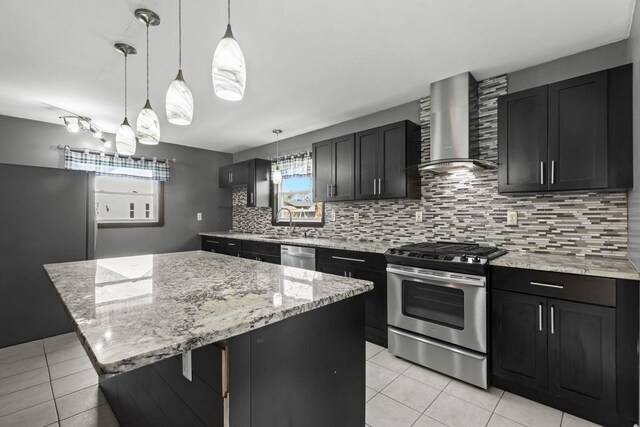 kitchen with plenty of natural light, wall chimney exhaust hood, light tile patterned flooring, and stainless steel appliances