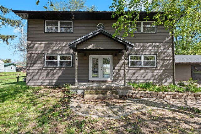 back of house featuring a lawn and french doors