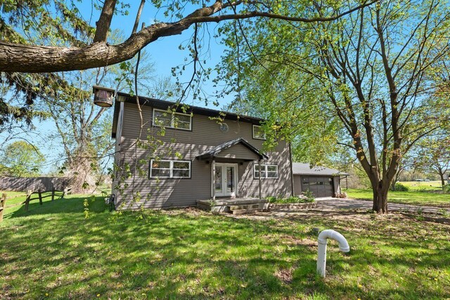 view of front of home featuring a garage, driveway, and a front yard