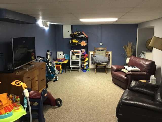 rec room with carpet floors and a paneled ceiling