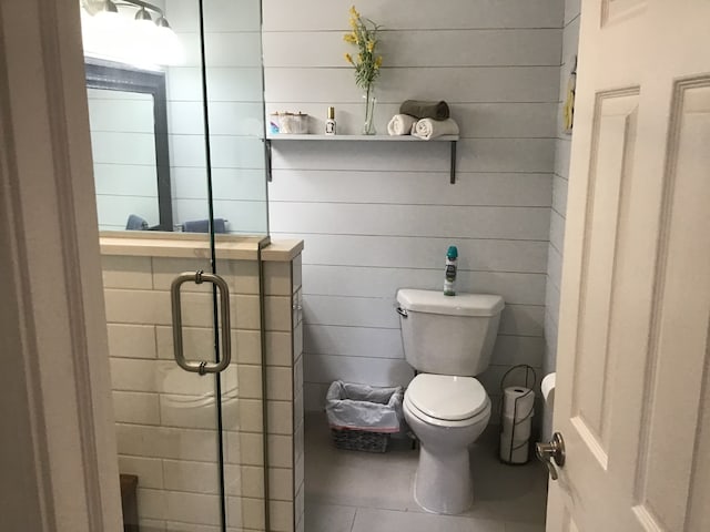 full bath featuring tile patterned floors, a stall shower, and toilet