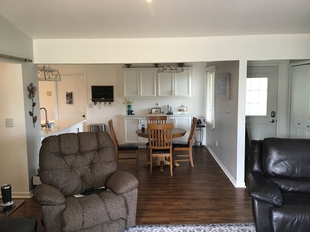 dining area with dark wood-type flooring and baseboards