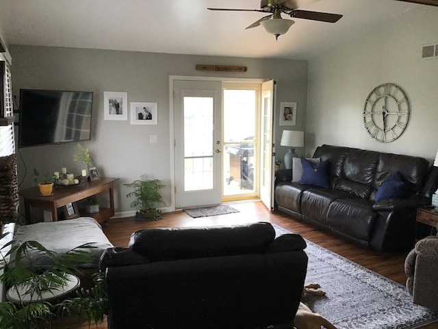 living room featuring visible vents, a ceiling fan, lofted ceiling, and wood finished floors