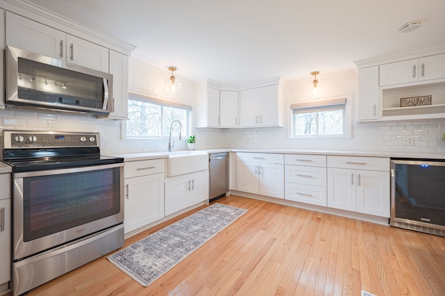 kitchen with a sink, wine cooler, backsplash, and stainless steel appliances