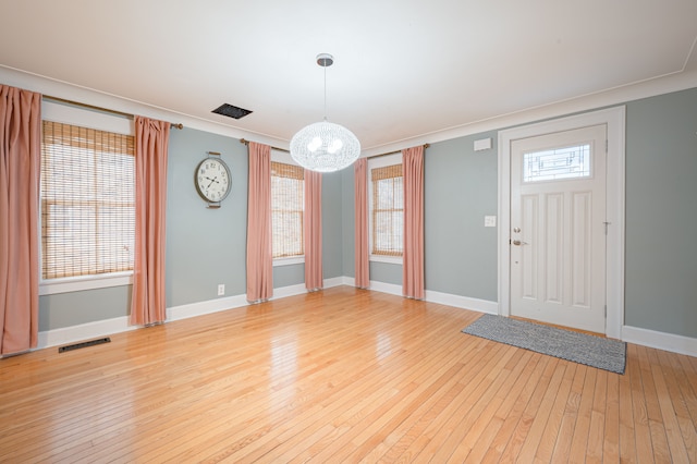 foyer with a chandelier, baseboards, visible vents, and light wood-style flooring