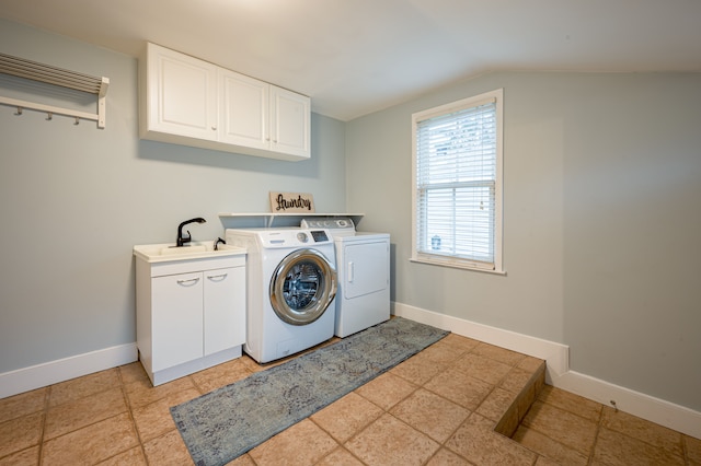 washroom featuring baseboards, a sink, cabinet space, and washing machine and clothes dryer
