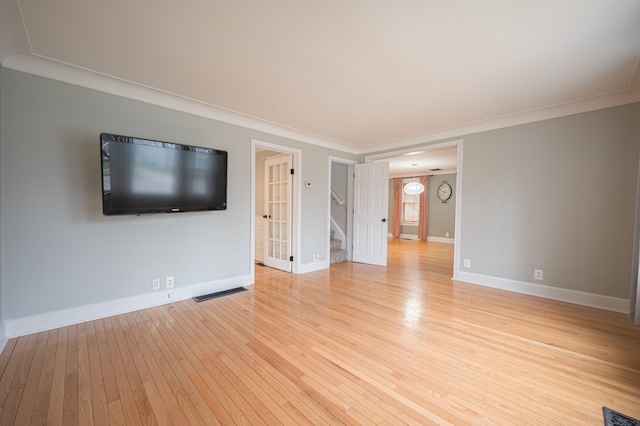 unfurnished living room featuring visible vents, ornamental molding, stairs, baseboards, and light wood-style flooring