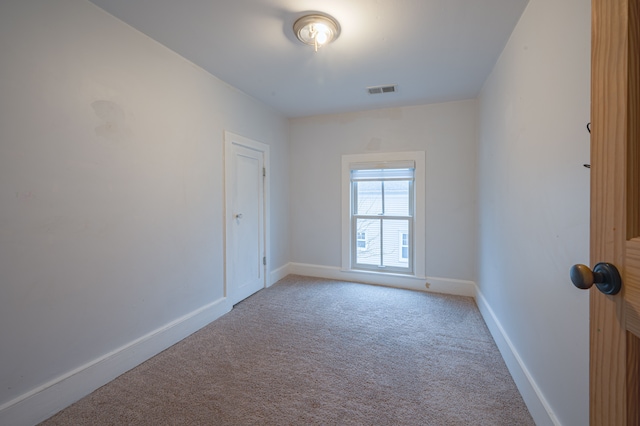 empty room with visible vents, baseboards, and carpet floors