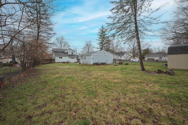 view of yard featuring fence, a storage unit, and an outdoor structure
