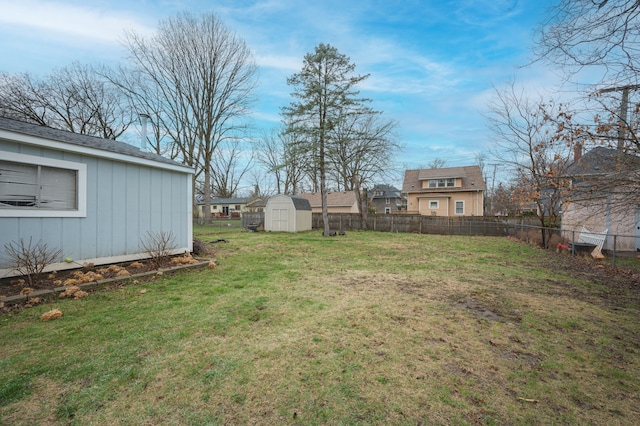 view of yard featuring fence, an outdoor structure, and a storage unit