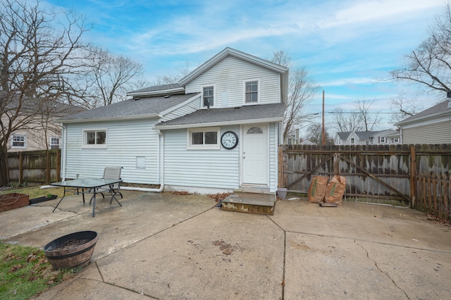 back of property with roof with shingles, a patio, and a fenced backyard
