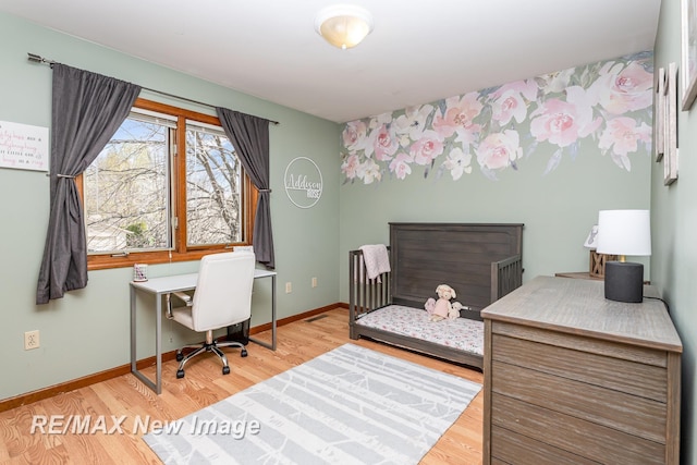 bedroom featuring baseboards, wood finished floors, and visible vents