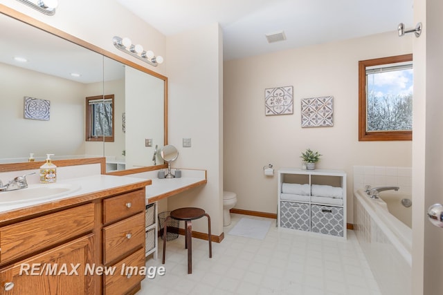 full bathroom featuring tiled bath, vanity, toilet, tile patterned floors, and visible vents