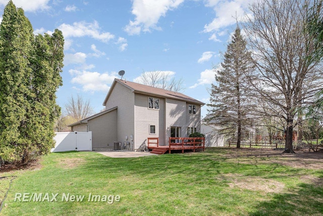 back of house featuring a wooden deck, a gate, central AC, fence, and a yard