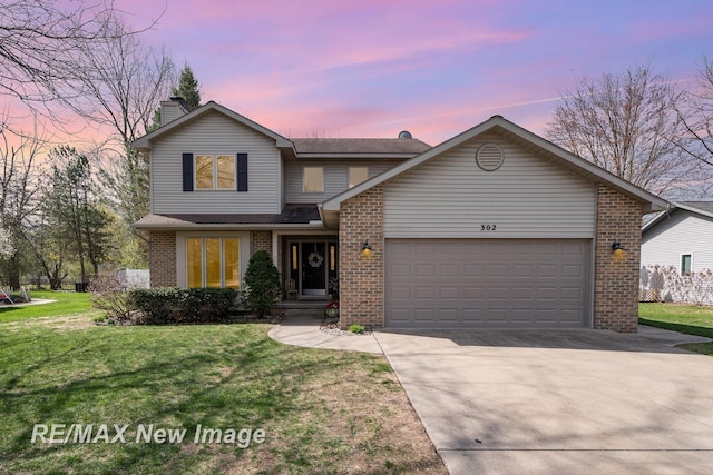 traditional home with an attached garage, brick siding, a front yard, a chimney, and concrete driveway