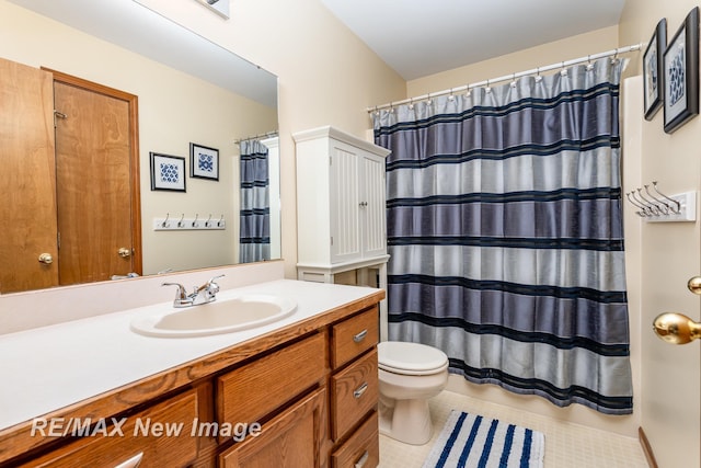 full bath featuring vanity, a shower with shower curtain, tile patterned floors, and toilet